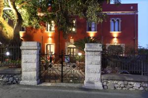 a wrought iron gate in front of a red house at Villa Astoria in Taormina