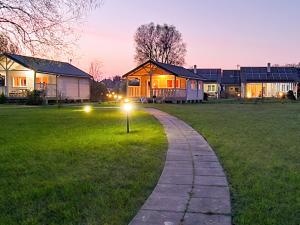 Un camino que conduce a una casa con luces en el césped. en Morska Polana, en Mielno