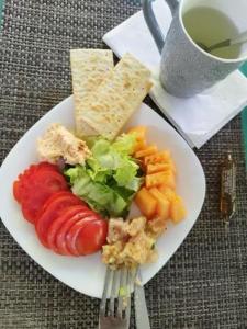 a plate of vegetables and crackers and a cup of coffee at Gites d'Arles Bungalow T1 BIS in Le Moule