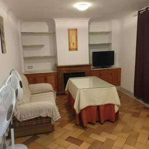 a living room with a table and a tv at Casa Rural MATEOS in El Puerto de Santa María