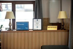 a desk with a laptop and two lamps on it at Pensiunea Nobila Băile Figa in Beclean