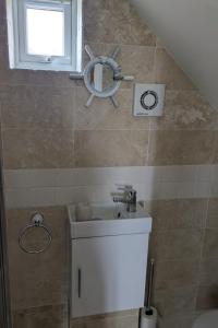 a bathroom with a sink and a mirror on the wall at The Crow's Nest in Mundesley +5 photos