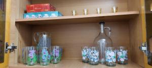a shelf with a bottle and glasses on it at Shkodra Stay in Shkodër