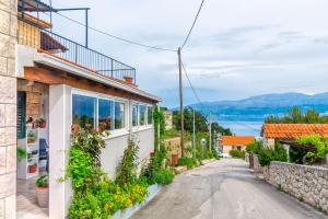 a street in a village with a house with flowers at Apartment New in Splitska