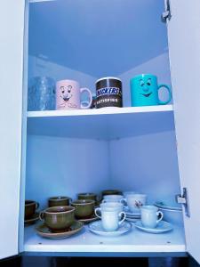 a cupboard filled with lots of cups and saucers at OLIVE Home in Durrës