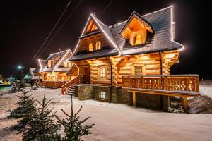 a log cabin in the snow at night at GÓRSKIE DOMKI Murzasichle in Murzasichle