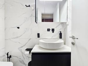 a white bathroom with a sink and a mirror at Elaine's Athens Riviera Studios in Athens +25 photos