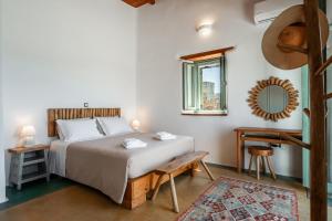 una camera da letto con un letto, un tavolo e uno specchio di Nerea Idyllic Sunset Home , Paros a Nea Cryssi Akti
