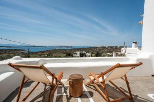 un paio di sedie sedute su un balcone con vista di Nerea Idyllic Sunset Home , Paros a Nea Cryssi Akti