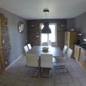 una sala da pranzo con un tavolo e sedie bianche di Villa blue Velvet a Yvré-lʼÉvêque Altre 6 foto