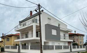 a white building on the side of a street at Adoniss Apartmentss 2 in Paralia Dionysiou
