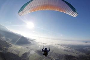 a person is flying a parachute in the sky at Camping & Glamping Grintovec in Preddvor