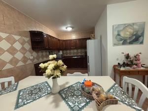 a kitchen with a table with a vase of flowers on it at Chalet Barranco Hondo Agaete in Agaete