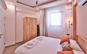a bedroom with a large white bed and a window at Happy Kaş Apart in Kaş