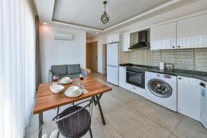 a kitchen with a table and a washer and dryer at Happy Kaş Apart in Kaş