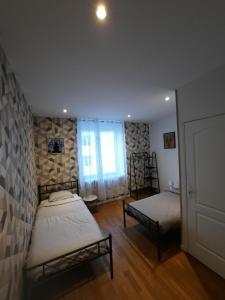 a bedroom with two beds and a window at La Halte Vesulienne in Vesoul