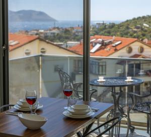a table with two glasses of wine on a balcony at Happy Kaş Apart in Kaş