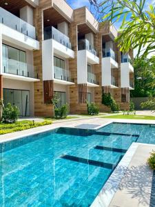 an apartment complex with a swimming pool in front of a building at Casa pé na areia - Triplex - Praia do Farol Velho - Salinópolis in Salinópolis