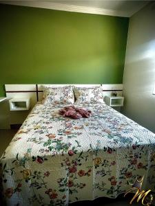a bedroom with a bed with a floral bedspread at Apt Completo e Confortável 300mt Praia de Croa Vermelha in Coroa Vermelha