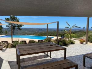 a patio with a table and a view of a pool at Quinta O Ninho Bed & Breakfast in Monchique