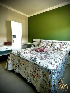 a bed in a bedroom with a green wall at Apt Completo e Confortável 300mt Praia de Croa Vermelha in Coroa Vermelha
