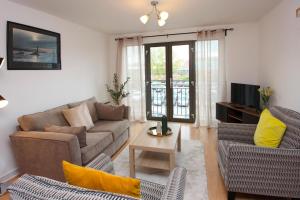 a living room with a couch and chairs and a tv at Albion Street Apartments in Wolverhampton