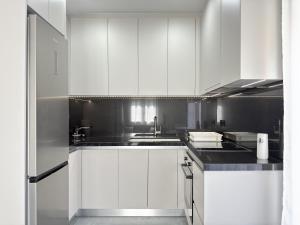 a kitchen with white cabinets and a sink at Kilada Luxury Apartment 2 in Koilás