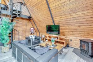 a living room with a couch and a tv at Hot Tub and Fire Pits Albrightsville A-Frame Cabin in Albrightsville