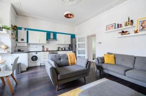 a living room with a couch and a kitchen at The Den in Croydon