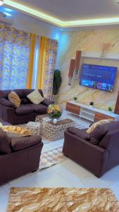 a living room with couches and a flat screen tv at Appartement mariste près de auchan in Darou Rhamane