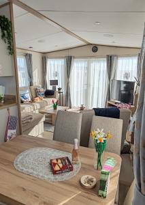 a living room with a table and a couch at Eagle's Den Caravan Holiday Retreat in Lossiemouth