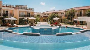 a large swimming pool in a courtyard with buildings at Flat Solar Água Bali by Qavi in Pipa