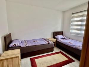 two twin beds in a room with a window at Valentina Apartman in Radanovići +2 photos