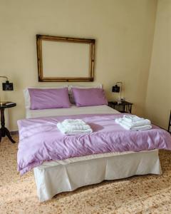a bedroom with a purple bed with two towels on it at Le Giramondo Appartamento Le Cavallerizze in Caserta