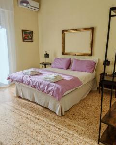 a bedroom with a large bed with pink pillows at Le Cavallerizze in Caserta