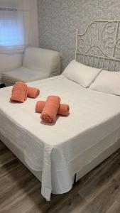 a bed with two orange towels on top of it at Galatea Puerto Sherry Apartamento in El Puerto de Santa María