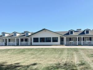 a large white house with a large yard at Hampton Motel in Hampton