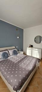 a bedroom with a large bed with a blue wall at Chia Sweet Home in Chia