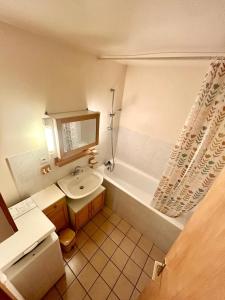 a bathroom with a sink and a toilet and a tub at Les chênes Rouges 4/p in Gérardmer +8 photos