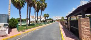 eine Straße mit Palmen am Straßenrand in der Unterkunft Preciosa casa con piscina y golf in El Portil