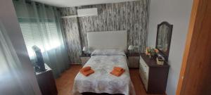 ein kleines Schlafzimmer mit einem Bett und einem Spiegel in der Unterkunft Preciosa casa con piscina y golf in El Portil