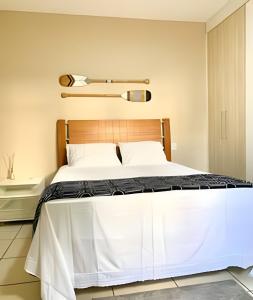 a bedroom with a large bed with white sheets at Flat espaçoso e com quintal na Zona Sul in São José