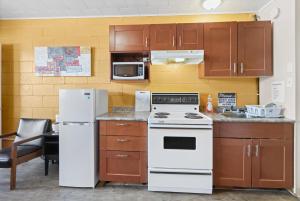 a kitchen with white appliances and brown cabinets at Dauphin Inn Express in Dauphin