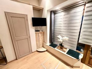 a room with a window with a door and a television at Agréable studio plein centre in Saint-Gaudens
