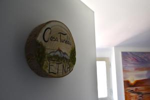 un reloj en una pared junto a una pintura en Casa Turiddu, en Taormina