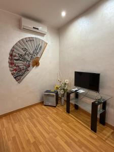 a living room with a television and a fan at Via Palazzo Sanremo in Sanremo +15 photos