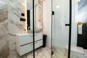 ザグレブにあるLuxury Apartmentの洗面台とガラスのシャワーを備えたバスルーム +26枚の写真