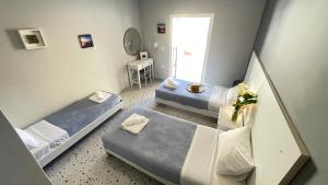 a small room with two beds and a mirror at Nine Muses Apartments in Kavos
