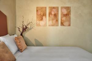 łóżko z trzema zdjęciami na ścianie w obiekcie Locanda Ca' Matilde w mieście Quattro Castella