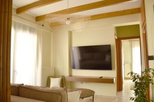 a living room with a couch and a flat screen tv at TheAretsouPlace, Luxury Apartment in Kalamaria, 200m from the Sea with Parking in Thessaloniki